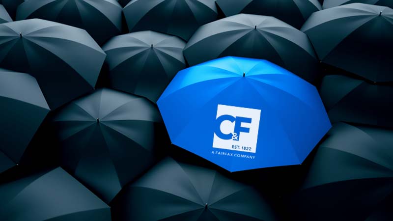 Tops of black umbrellas and one blue umbrella with the C&F logo on it