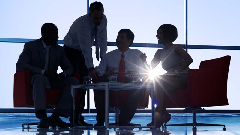 Silhouette of four executives meeting