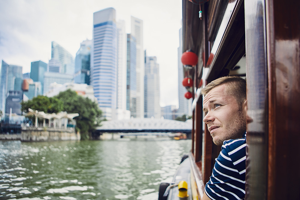 young man exploring city from a boat