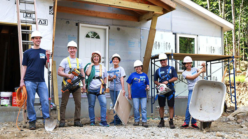 C&F volunteers stand in front of Habitat home during a volunteer event.