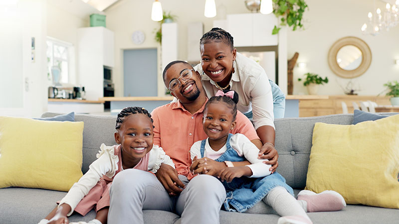 Smiling family sitting on couch